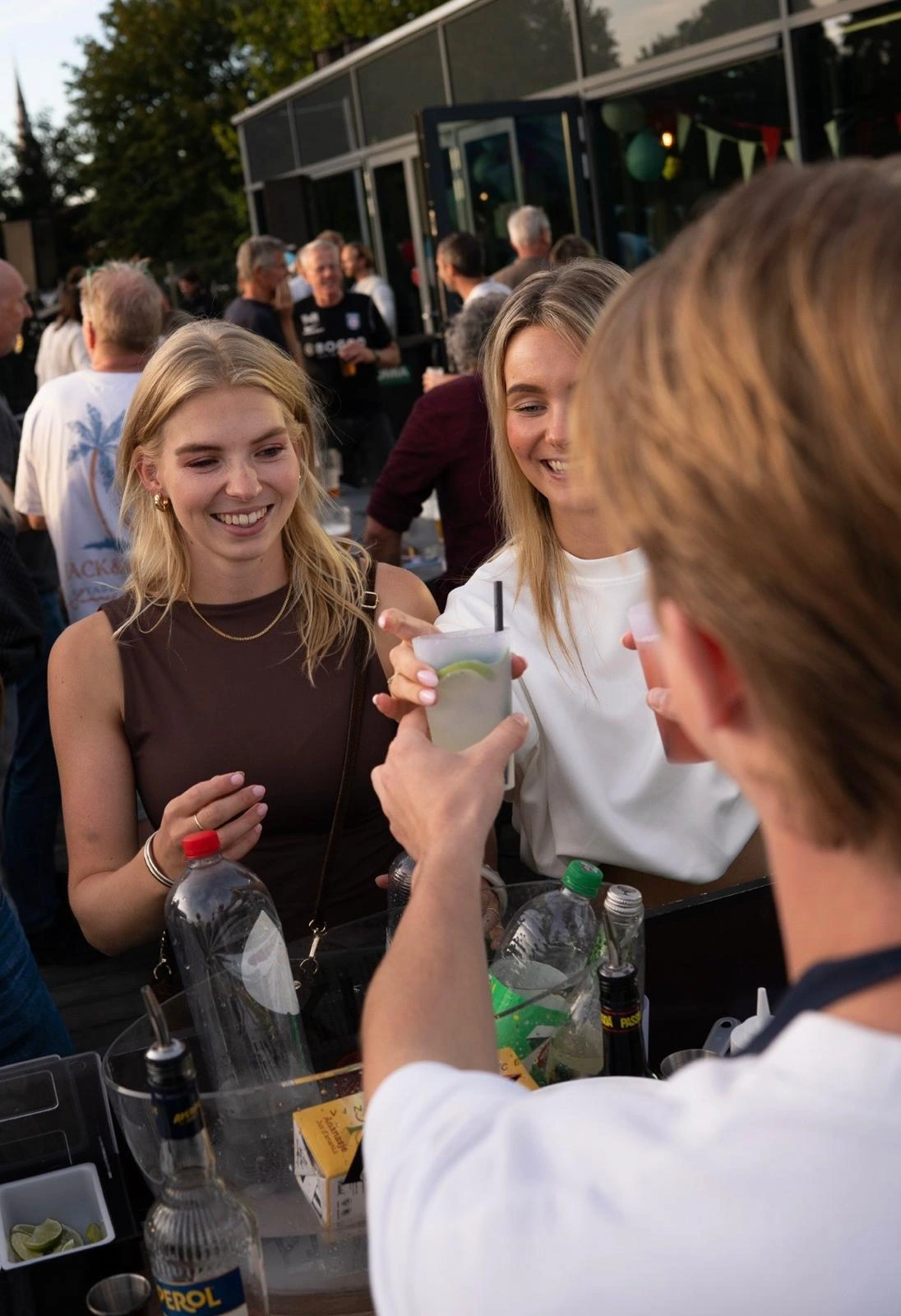 Een bartender serveert drankjes aan gasten bij de Zestbar
